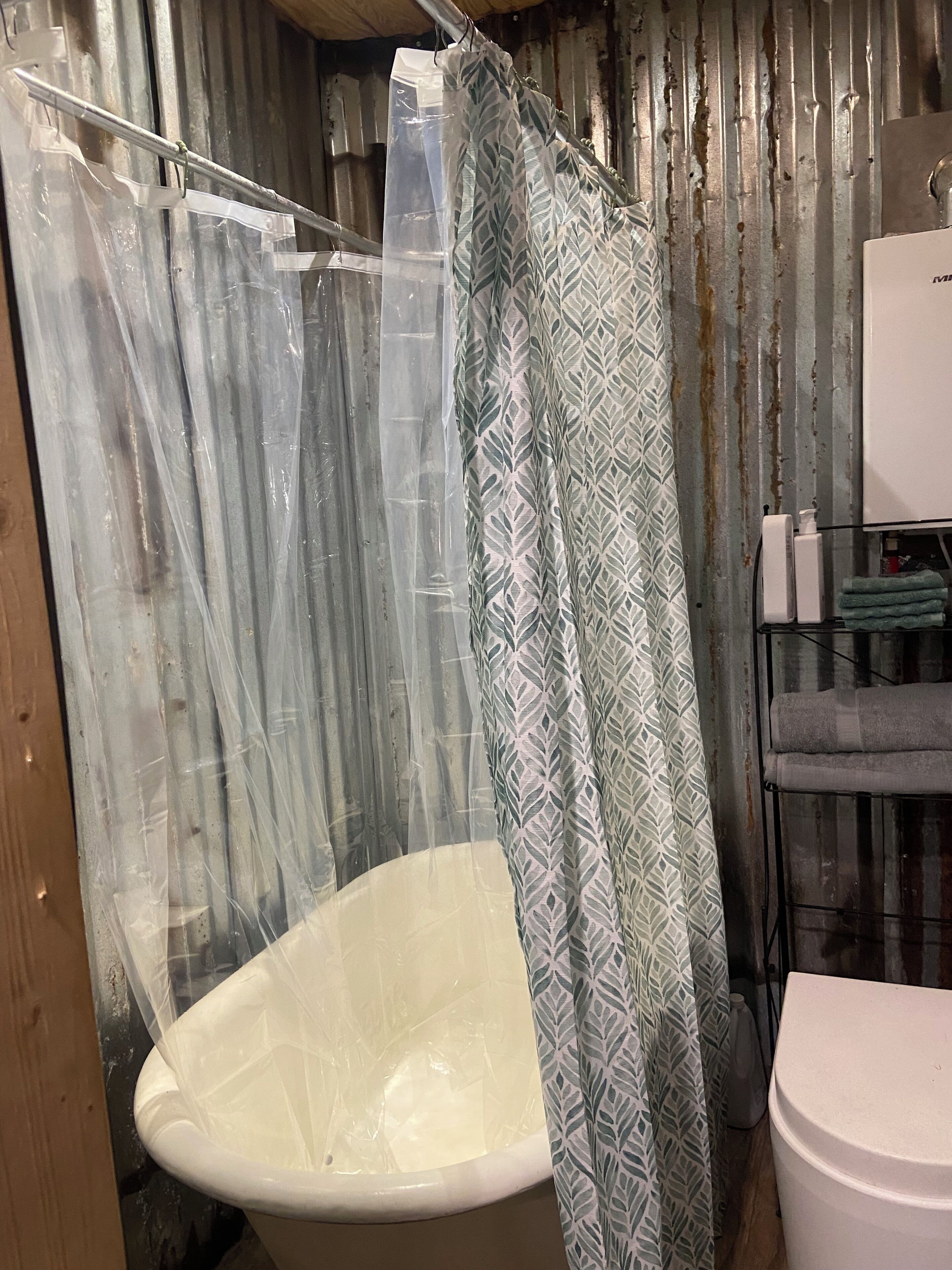 Un bagno con doccia, toilette e porta asciugamani.
