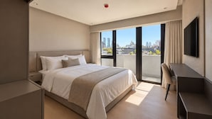 A modern hotel room with a large bed, a desk, and a city view. - Lev Hotel (Buenos Aires)
