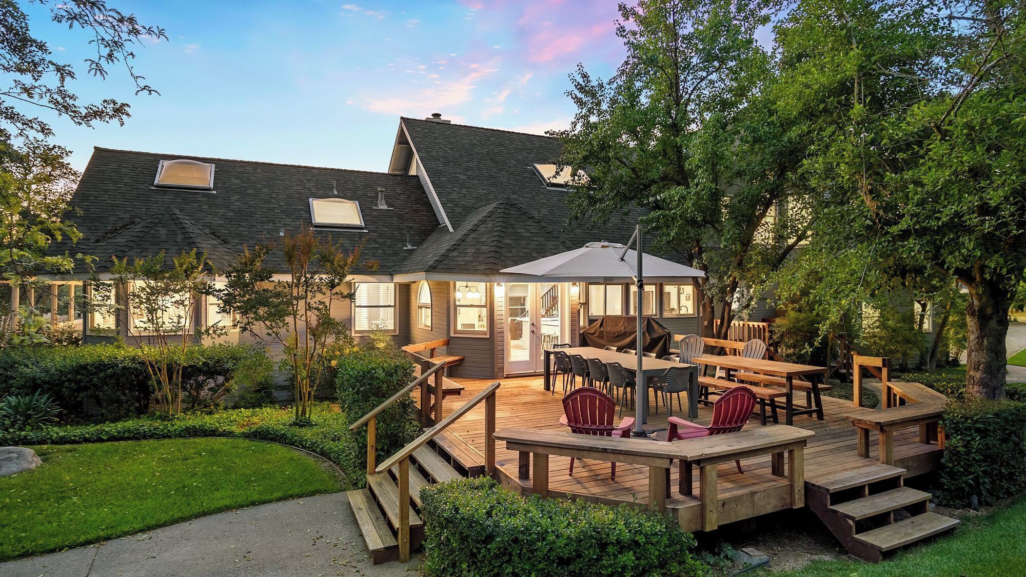 A house with a deck, outdoor seating, and a garden.