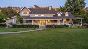 A two-story house with a front porch, a covered entryway, and a well-maintained lawn. - Oaks and Roses Ranch by Avantstay Pool + Game Room Paso Wine Country (Paso Robles)