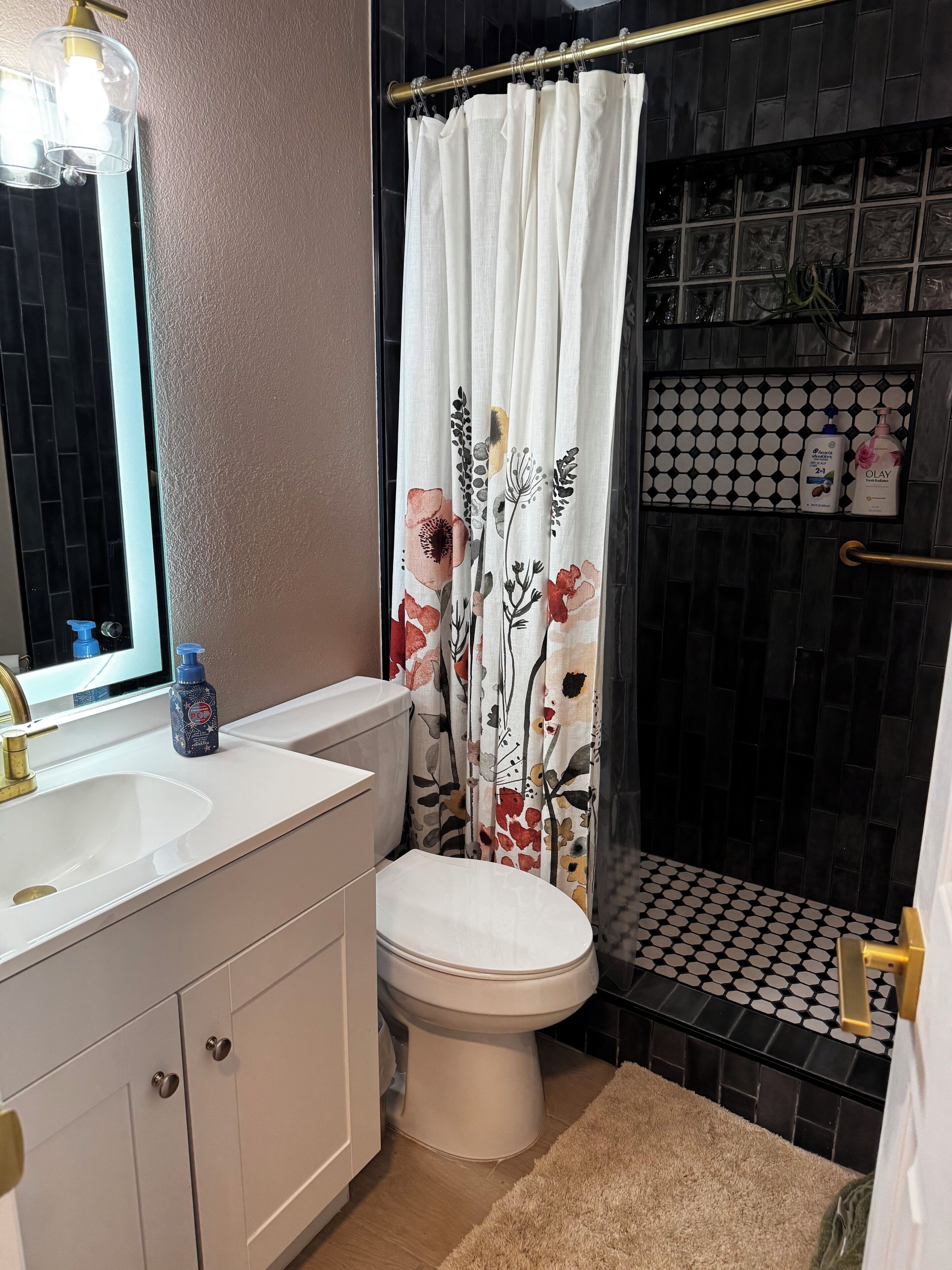 Een badkamer met toilet, wastafel en douchegordijn.