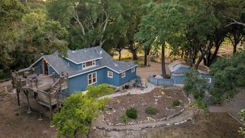Uma casa de dois andares com varanda e quintal cercado.