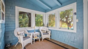 A room with blue walls, white trim, wicker chairs, a small table, and large windows with a view of trees. - Dunning Ranch Guest Suite Two by Avantstay 40 Acres + Vineyard Views Paso Robles Wine Country (Paso Robles)