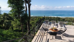 Eine Terrasse mit Sitzgelegenheiten und Blick aufs Meer.