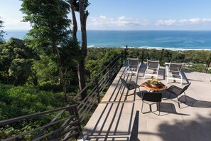 Eine Terrasse mit Sitzgelegenheiten und Blick aufs Meer.
