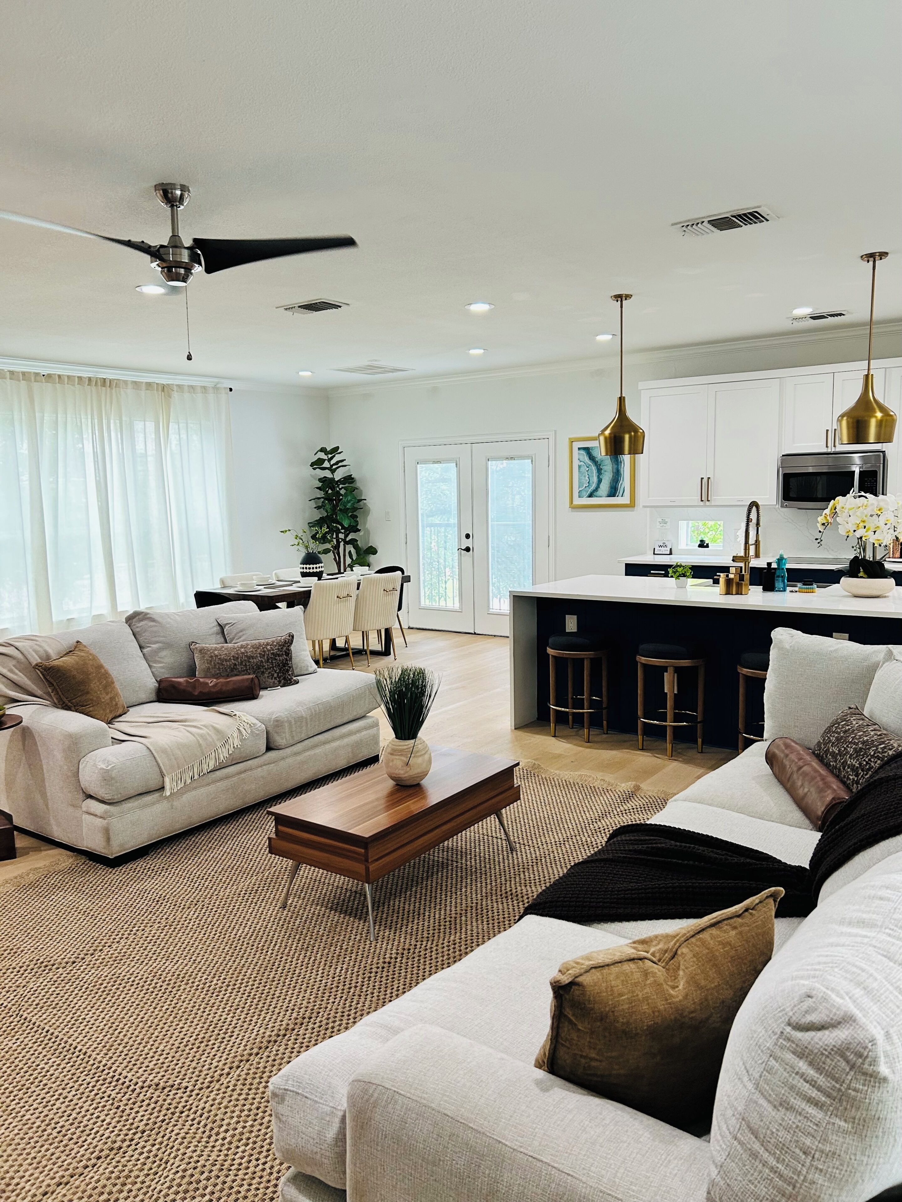 A modern living room with a sofa, coffee table, and a dining area with chairs.