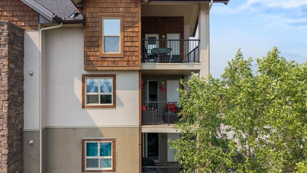 Ein mehrstöckiges Wohngebäude mit einem Balkon im zweiten Stock.