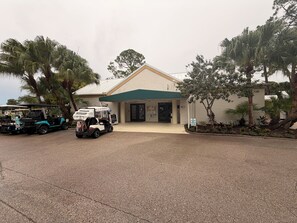 A building with a green awning, a sign reading 'PRO SHOP,' and a golf cart parked in front. - Resort style living in North Fort Myers! (North Fort Myers)
