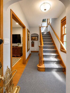 A staircase with wooden railings leading to a landing with a flat ceiling and a light fixture. - Luxury Furnished Executive Residence 5 bedroom in Chevy Chase near Lafayette (Washington)