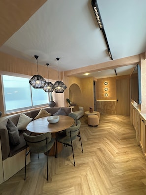Ein modernes Interieur mit Essbereich, Sitzgelegenheiten und einer Küche.