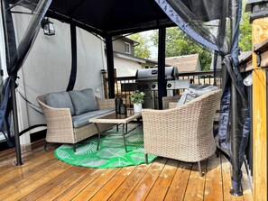 An outdoor patio area with wicker furniture, a grill, and a covered seating area. - 3 bedroom 2 bath I 1 min walk to beach (Georgina)