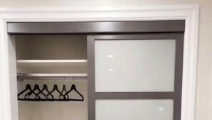 Vestidor con puerta corredera, estantes y barra para colgar ropa.