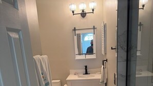 Une salle de bain comprenant des toilettes, un lavabo et un espace douche.