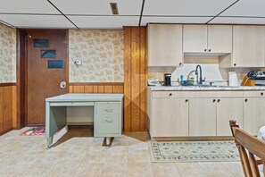 A kitchen with a wooden cabinet, a sink, and a countertop.