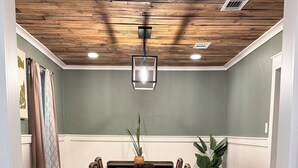 A dining area with a wooden ceiling, a table with chairs, a rug, and a potted plant. - 3-bedroom house in peaceful Foley perfect for relaxing getaways (Foley)