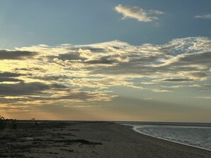A beach with a wide sandy shore and a clear sky with scattered clouds. - Chaleville Barrinha (Cajueiro da Praia)