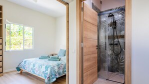 A bedroom with a bed, a window, a shower, and a wooden wardrobe. - Dreamscape Levada (Funchal)