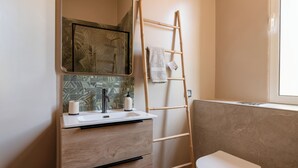A bathroom with a wooden vanity, a mirror, a sink, and a toilet. - Dreamscape Levada (Funchal)