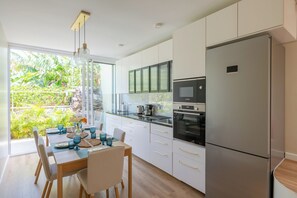 Eine moderne Küche mit einem großen Kühlschrank, einem eingebauten Backofen und einer Mikrowelle.
