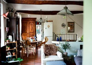 A cozy kitchen with wooden beams, a dining table, and various kitchen appliances. - Provence Amour -Tranquil House w patio & parking (Cotignac)