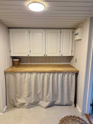 A kitchen with white cabinets, a wooden countertop, and a ceiling light. - Renovated seaside home with ocean view (Frederikshavn)