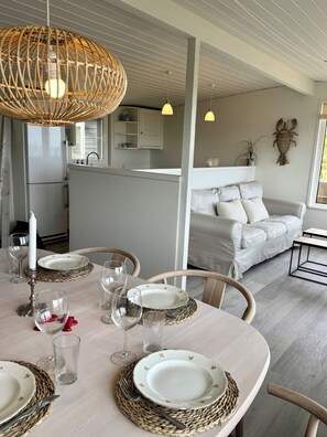 A dining area with a round table set for four, surrounded by chairs.