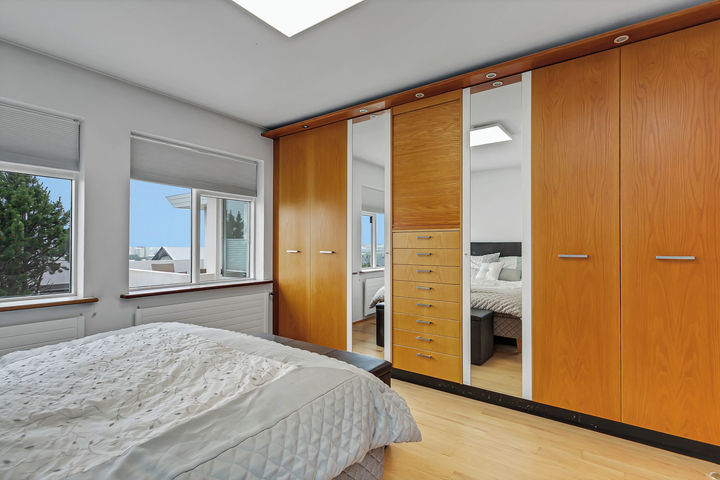 Une chambre à coucher avec un lit, une armoire et une fenêtre.