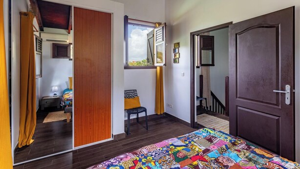 A bedroom with a bed, a chair, a window, and a door. - Beachfront Villa - Private Paradise (Le Robert)