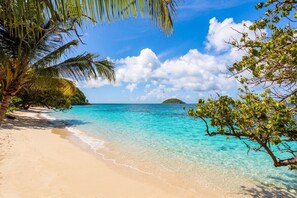 A beach with clear turquoise water, a sandy shore, and a small island in the distance. - Les Villas de Solange - Azur & Canopée (La Trinité)