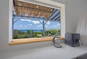 A kitchen with a view of the ocean, a hammock, and a coffee maker. - Les Villas de Solange - Azur & Canopée (La Trinité)