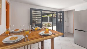 Een moderne keuken met een ontbijttafel, compleet met borden eten, glazen en een koelkast.