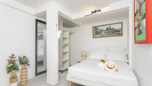 Een slaapkamer met een bed, een garderobe, een schilderij en twee decoratieve vazen.