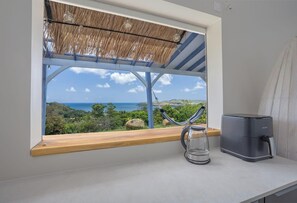 A kitchen with a view of the ocean, a hammock, and a coffee maker. - La Villa de Solange - Azur (La Trinité)