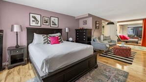 A bedroom with a large bed, a dresser, a chair, and a small ottoman. - Black Hills Townhome -Community Pool-Near Downtown (Rapid City)
