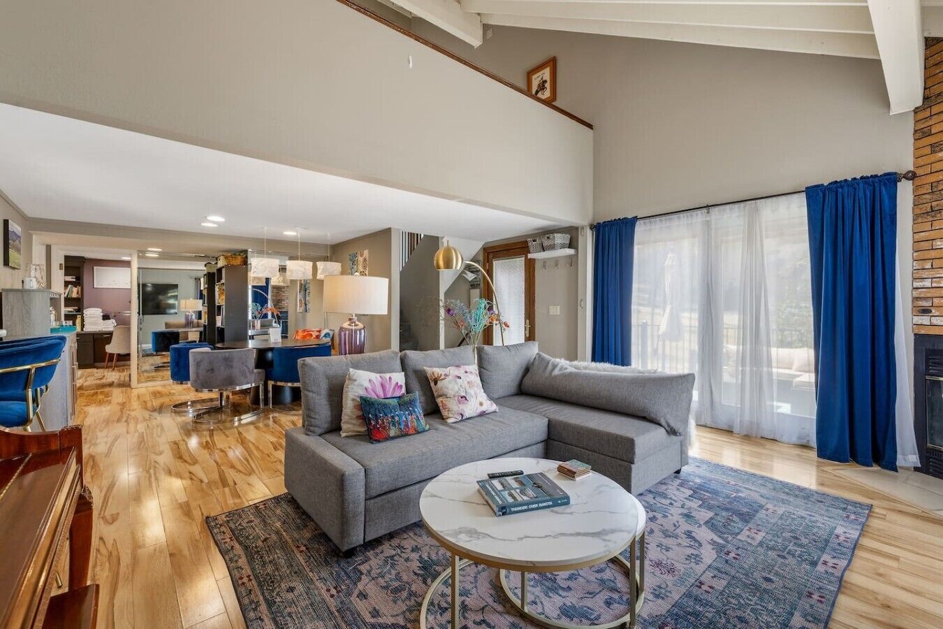 A modern living room with a grey sofa, a round coffee table, and a patterned rug.