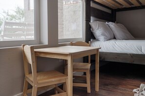 A room with a wooden desk, a bed with white bedding, and a window. - Casa Blanca Old Town Estate + Vineyard View + Pool (Cottonwood)