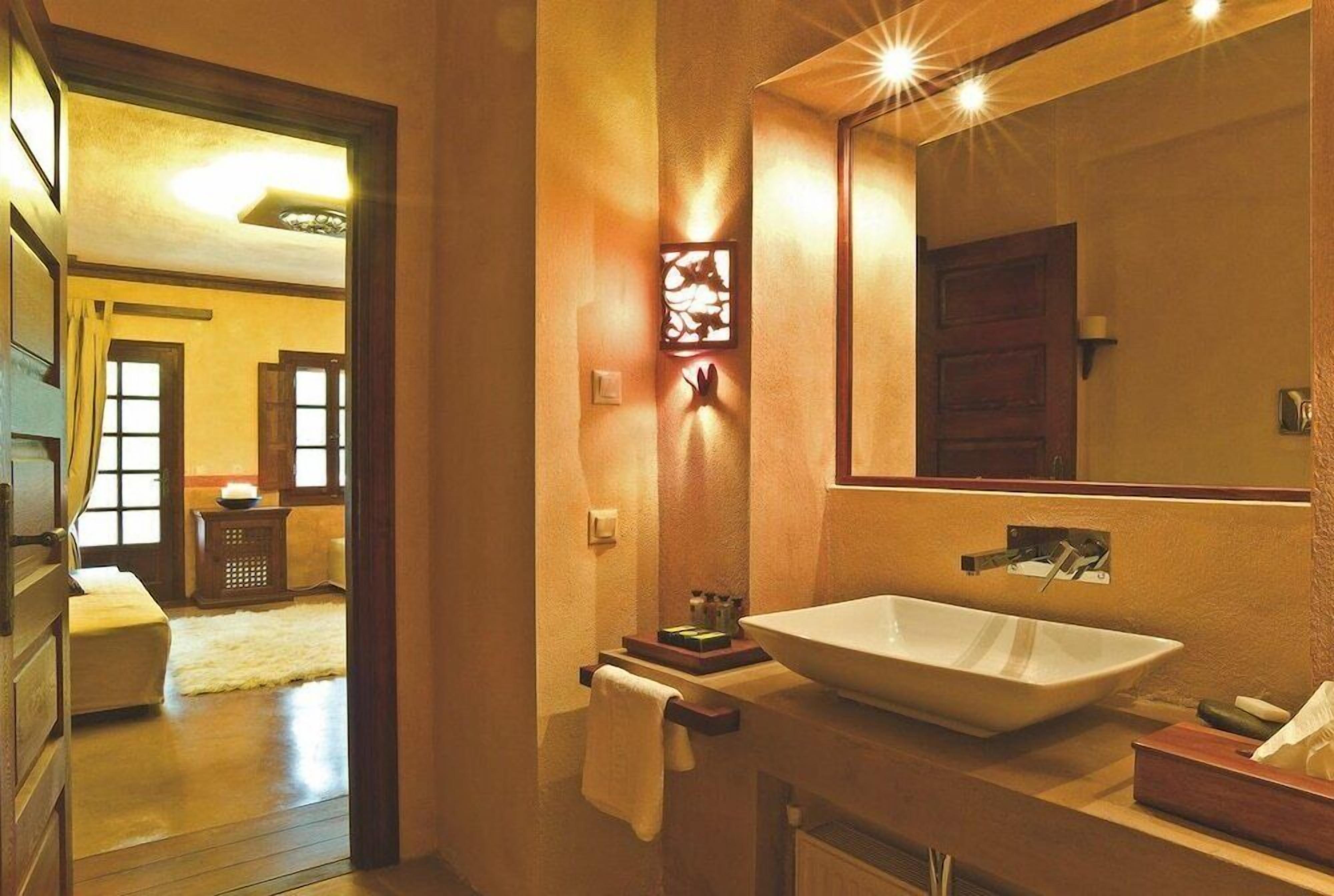 A bathroom with a large mirror, a vessel sink, and a towel rack.