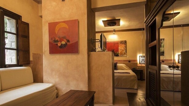 Un ambiente acogedor con un sofá, una mesa de madera y una cama con mesita de noche.