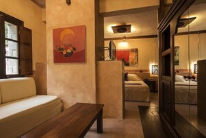 Un ambiente acogedor con un sofá, una mesa de madera y una cama con mesita de noche.