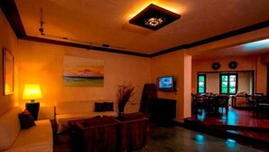Una sala de estar con un sofá, una mesa de centro, un televisor y un comedor con sillas y una mesa.