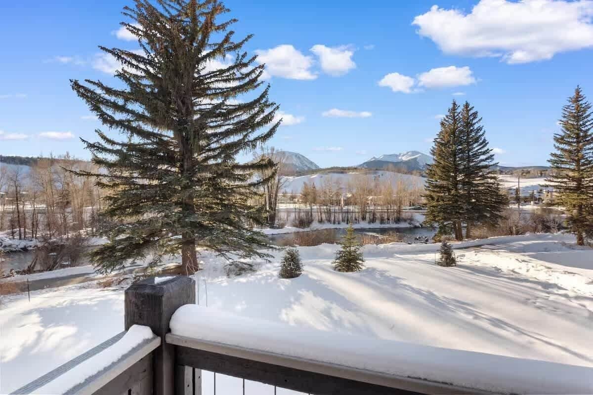 A snowy landscape with evergreen trees and a clear sky.