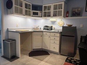 A compact kitchen with a microwave, toaster, and refrigerator. - Garden level studio apartment downtown Boulder (Boulder)
