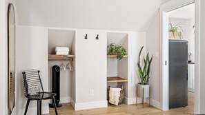 Eine moderne Küche mit integriertem Kühlschrank, Holzregalen und einem Stuhl.