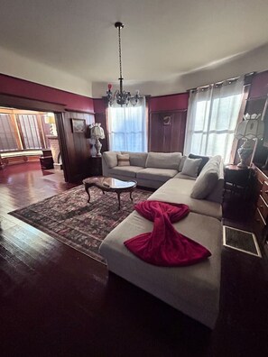 A living room with a sofa, a coffee table, and a chandelier. - Historic Victorian/Walk to Midtown restaurants (Sacramento)