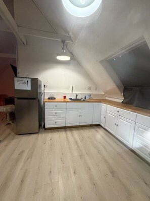 A kitchen with white cabinets, a stainless steel refrigerator, and a wooden countertop. - Historic Victorian/Walk to Midtown restaurants (Sacramento)