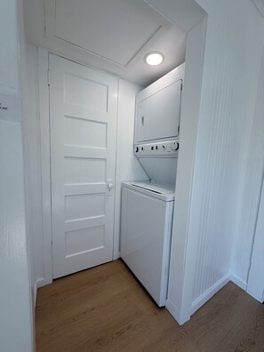 A laundry room with a white door, a washing machine, and a dryer.