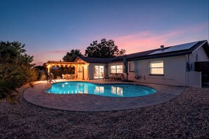 A swimming pool with a patio area, a covered seating area, and a house with a garage. - Modern Designer 3BD 2BA Pool Retreat 5 min to Beach (Seminole)
