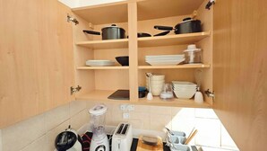 A kitchen with wooden cabinets, a countertop with a blender, toaster, and a coffee maker.