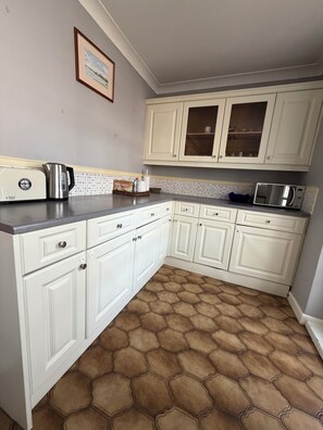 A kitchen with white cabinets, a toaster, a kettle, and a microwave. - 5 Bed Contractor / Families and Groups accommodation (Ipswich)
