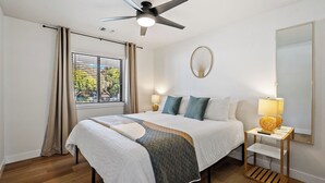A hotel room with a bed, a ceiling fan, a bedside table with a lamp, and a window with curtains. - Prickly Pear Paso by Avantstay Fire Pit + BBQ Patio Walkable Downtown Paso (Paso Robles)